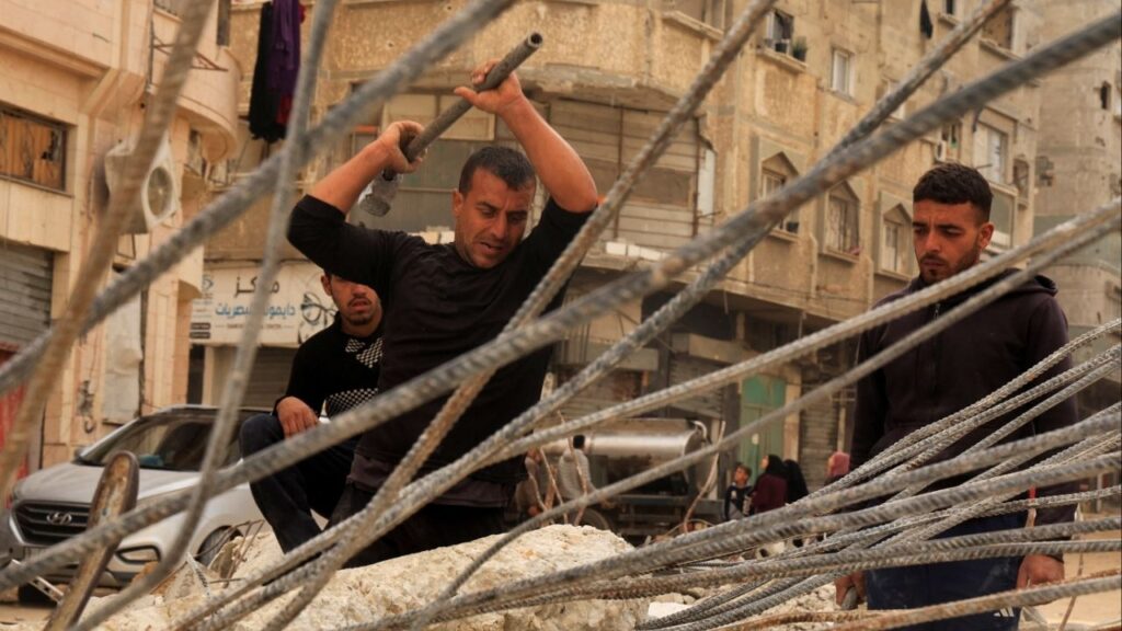 Palestinian workers break concrete to extract steel bars from destroyed homes, relying only on simple hand tools amid a severe shortage of construction materials caused by long-standing restrictions on the entry of cement and iron, in Khan Younis in the southern Gaza Strip, December 9, 2025. (Reuters/Haseeb Alwazeer)