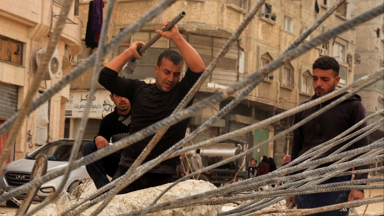 Palestinian workers break concrete to extract steel bars from destroyed homes, relying only on simple hand tools amid a severe shortage of construction materials caused by long-standing restrictions on the entry of cement and iron, in Khan Younis in the southern Gaza Strip, December 9, 2025. (Reuters/Haseeb Alwazeer)