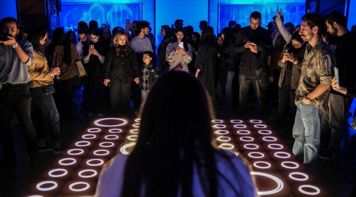 People look on at an art installation during Design Week at the University of Tehran, Iran on Nov. 13, 2025. Scores of people traversed the city to experience Tehran Design Week, a festival of gigantic colorful art installations, light shows and live music in multiple locations. (Arash Khamooshi/The New York Times)
