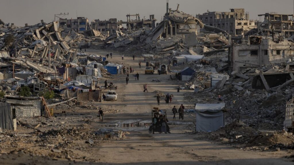 People walk between destroyed buildings in the Jabalia camp near Gaza City, Nov. 18, 2025. Nearly two months into the cease-fire between Israel and Hamas, Israel continues to bar international journalists from freely entering the Gaza Strip. (Saher Alghorra/The New York Times)