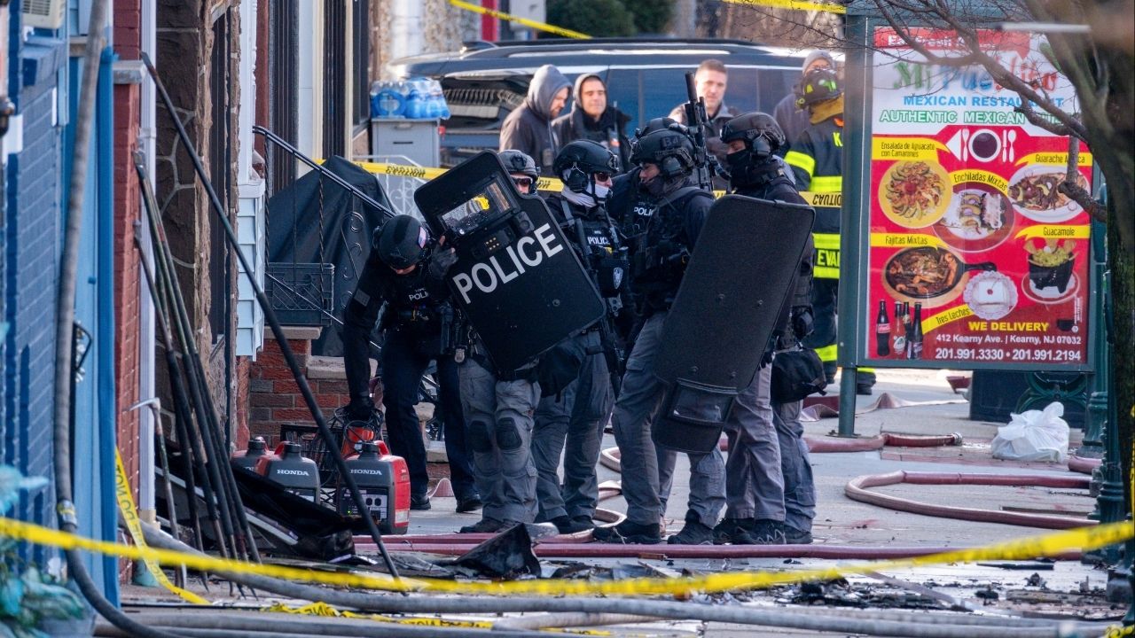 Police officers and a SWAT team at the scene where the suspect in a bow-and-arrow killing was hiding in Kearny, N.J., on Sunday, Dec. 21, 2025. A man was arrested on Sunday after a bizarre killing with a bow and arrow, an hours long standoff and an early-morning fire that shut down a street in a New Jersey suburb. (Dakota Santiago/The New York Times)