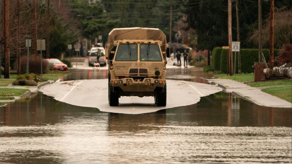 Washington National Guard personnel use a military vehicle to assist in search and rescue operations, as an atmospheric river brings rain and flooding to the Pacific Northwest, in Burlington, Washington, U.S., December 12, 2025. (Reuters/David Ryder)