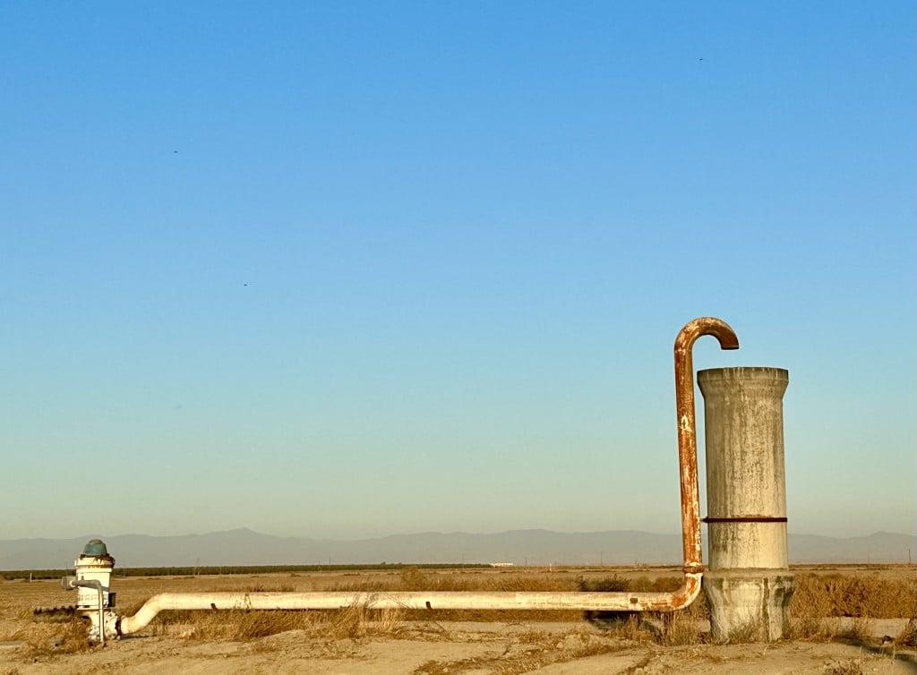 Image of a blue sky and a groundwater well in a farm field in the San Joaquin Valley