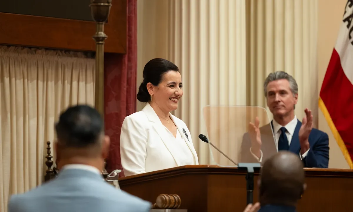 Image of a smiling Monique Limón being sworn in as California Senate leader while Gov. Gavin Newsom applauds.