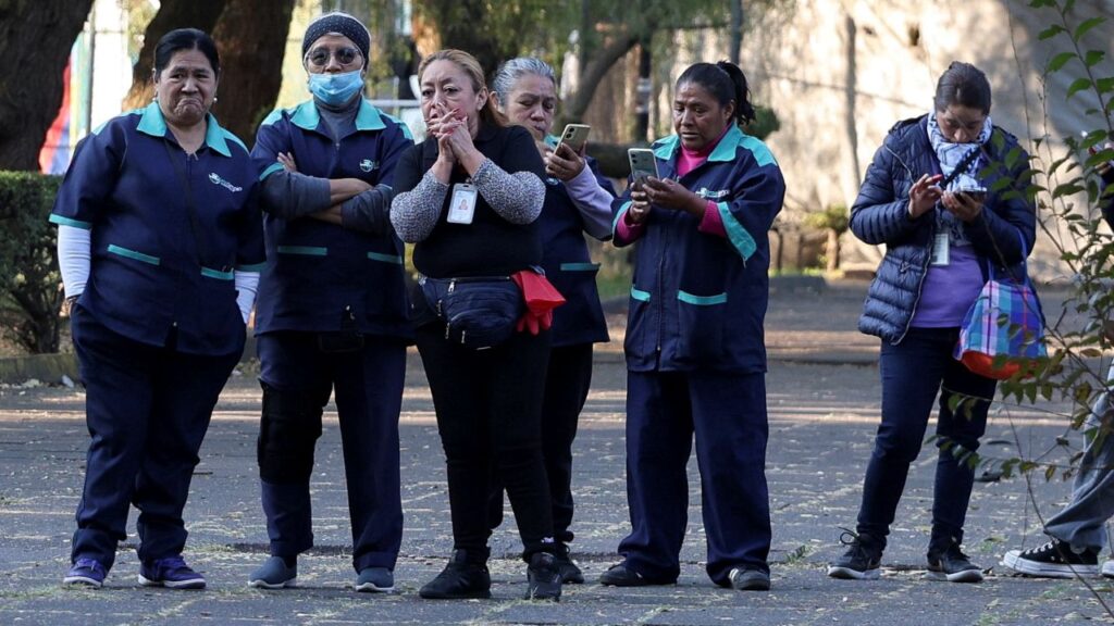 Image of people standing outside on the sidewalk following an earthquake in Mexico City