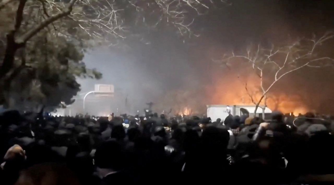 Image of flames and smoke rising above protesters in Iran