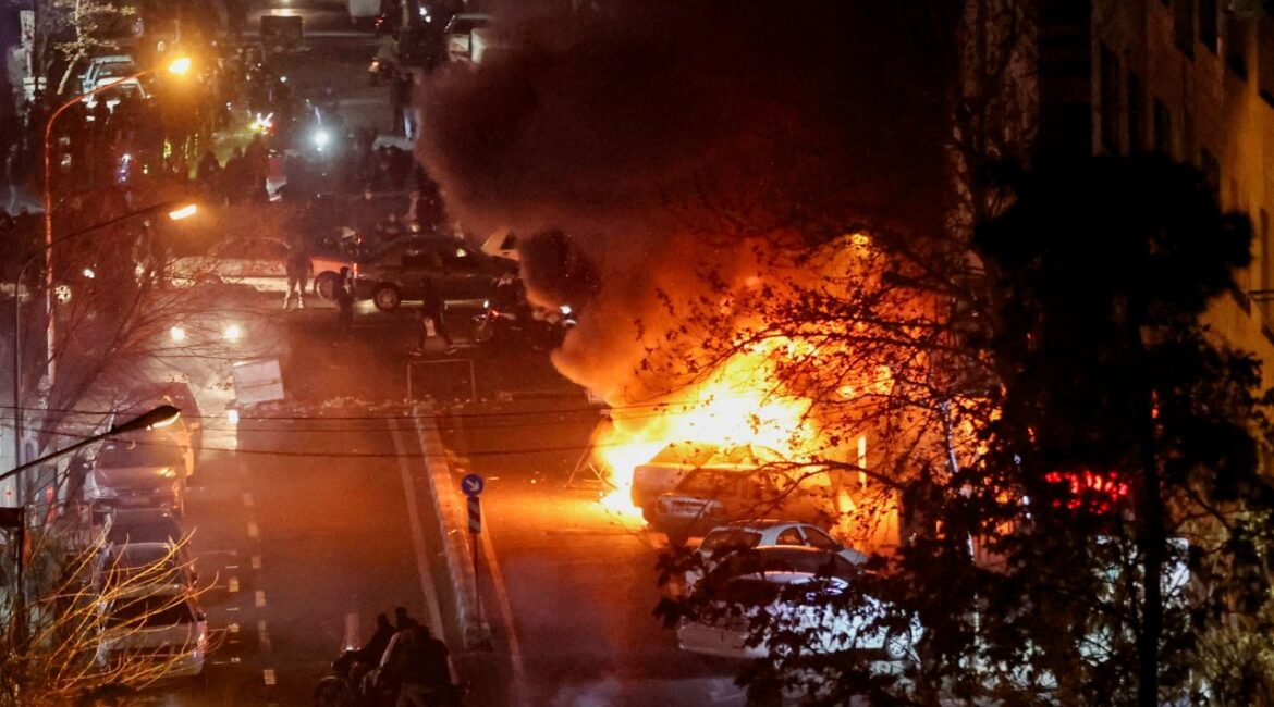 Image of cars burning at night in Tehran, Iran, during a street protest