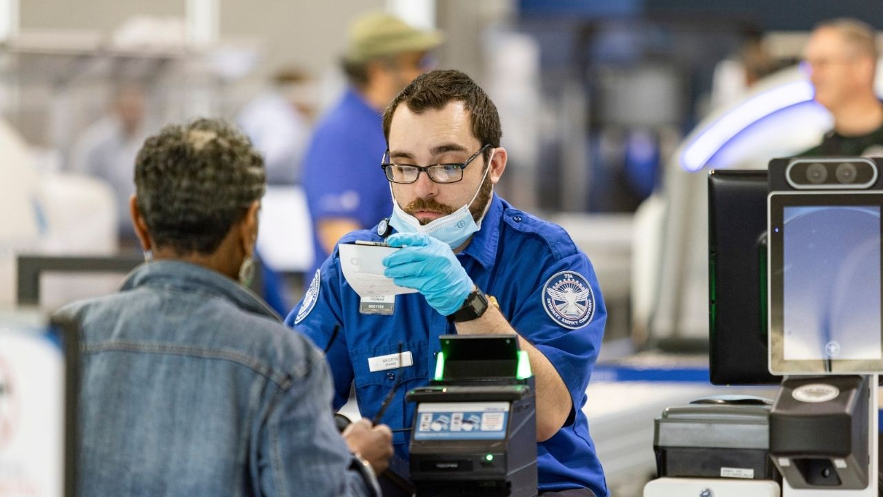 A TSA worker checks a traveler’s ID at Oakland International Airport in Oakland, Calif., May 7, 2025. As of Feb. 1, 2026, passengers without a Real ID will be required to pay a $45 fee in order to fly from U.S. airports, the Transportation Security Administration announced on Monday, Dec. 1. (Jason Henry/The New York Times)