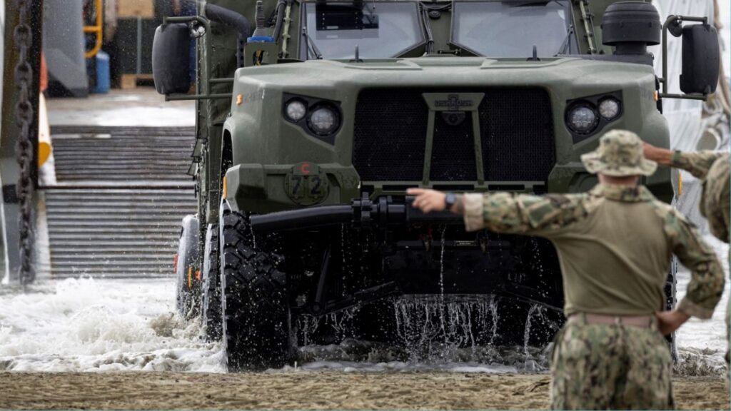 A U.S. Navy Landing Craft Utility (LCU) unloads a Joint Light Tactical Vehicle (JLTV) as sailors guide it ashore during amphibious operations in Arroyo, Puerto Rico, December 9, 2025. (Reuters/Ricardo Arduengo)