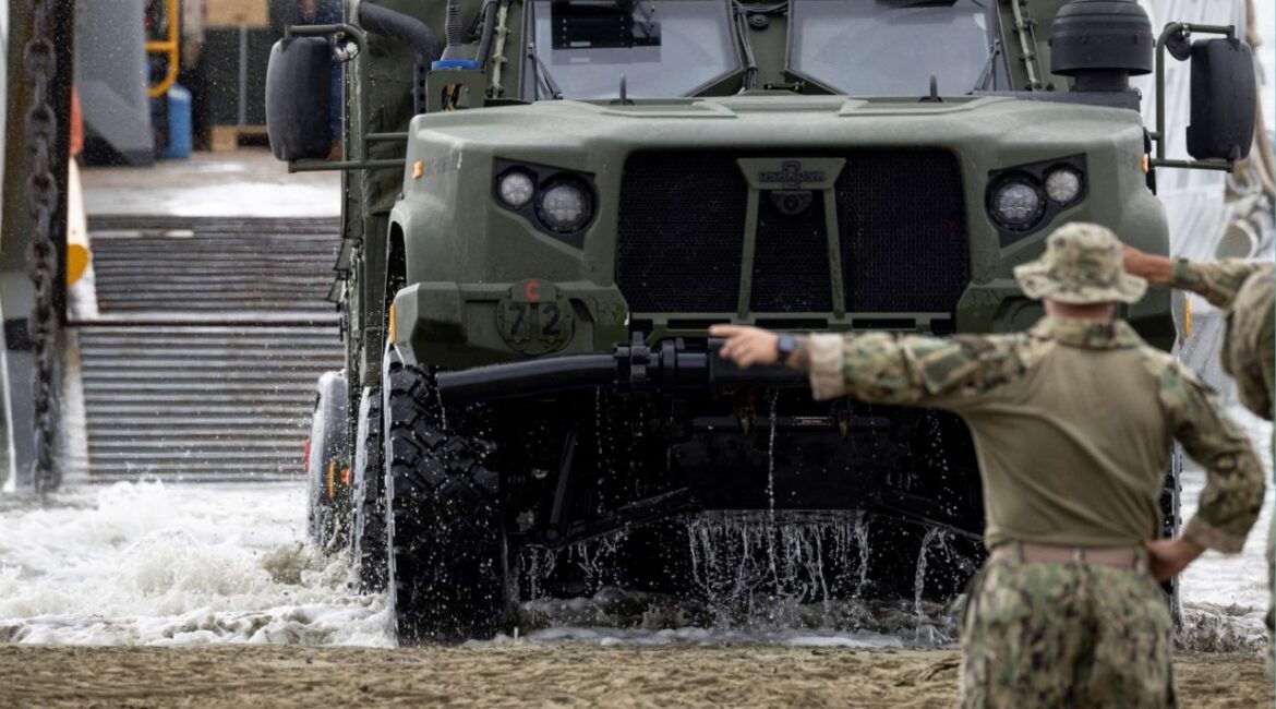A U.S. Navy Landing Craft Utility (LCU) unloads a Joint Light Tactical Vehicle (JLTV) as sailors guide it ashore during amphibious operations in Arroyo, Puerto Rico, December 9, 2025. (Reuters/Ricardo Arduengo)