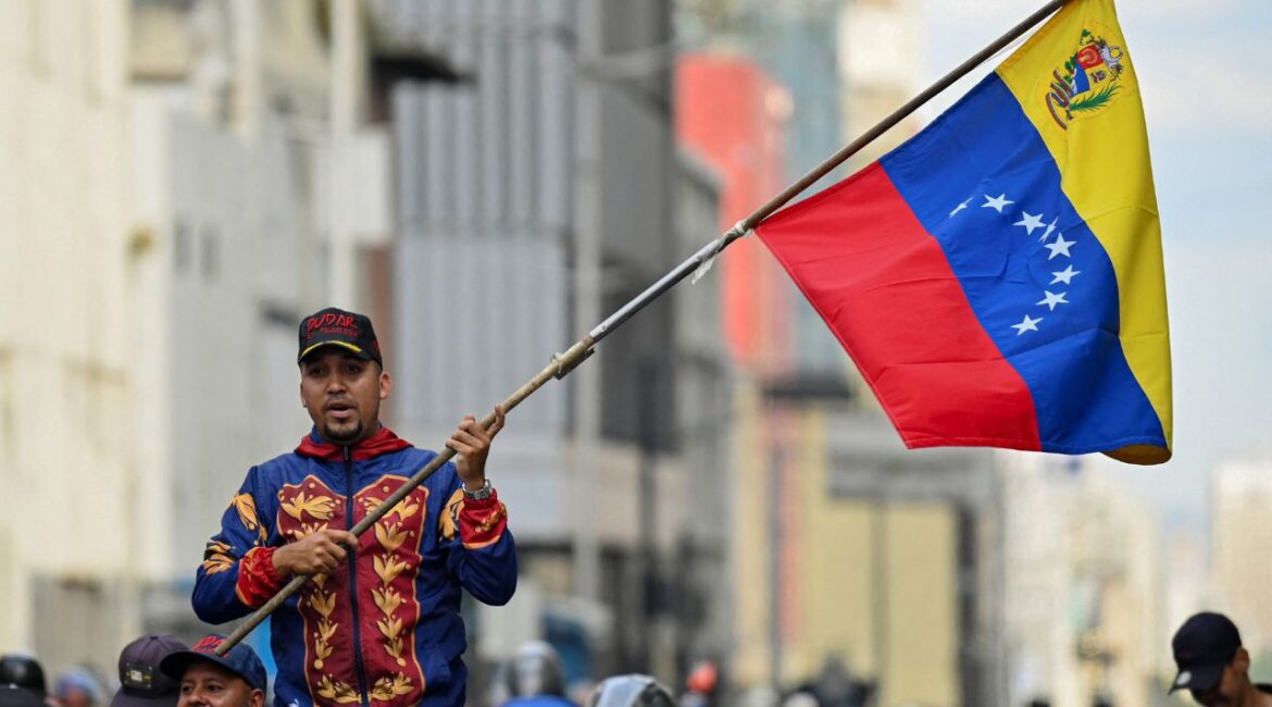 A demonstrator holds a Venezuelan flag during a march outside the National Assembly, on the day Vice President Delcy Rodriguez was formally sworn in as Venezuela's interim president, as U.S.-deposed President Nicolas Maduro appeared in a New York court after the Trump administration removed him from power, in Caracas, Venezuela January 5, 2026. (Reuters/Maxwell Briceno)