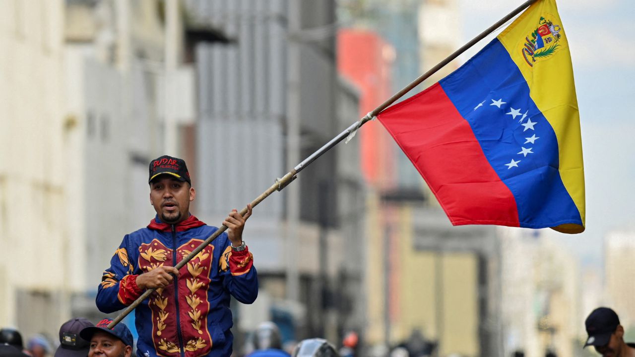 A demonstrator holds a Venezuelan flag during a march outside the National Assembly, on the day Vice President Delcy Rodriguez was formally sworn in as Venezuela's interim president, as U.S.-deposed President Nicolas Maduro appeared in a New York court after the Trump administration removed him from power, in Caracas, Venezuela January 5, 2026. (Reuters/Maxwell Briceno)