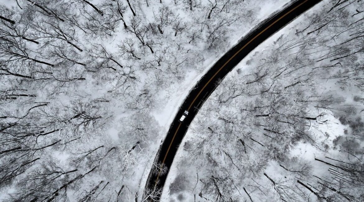 A drone view of a car driving through the snow covered woods of Blauvelt State Park in Orangetown, New York, U.S., December 27, 2025. (Reuters/Mike Segar)