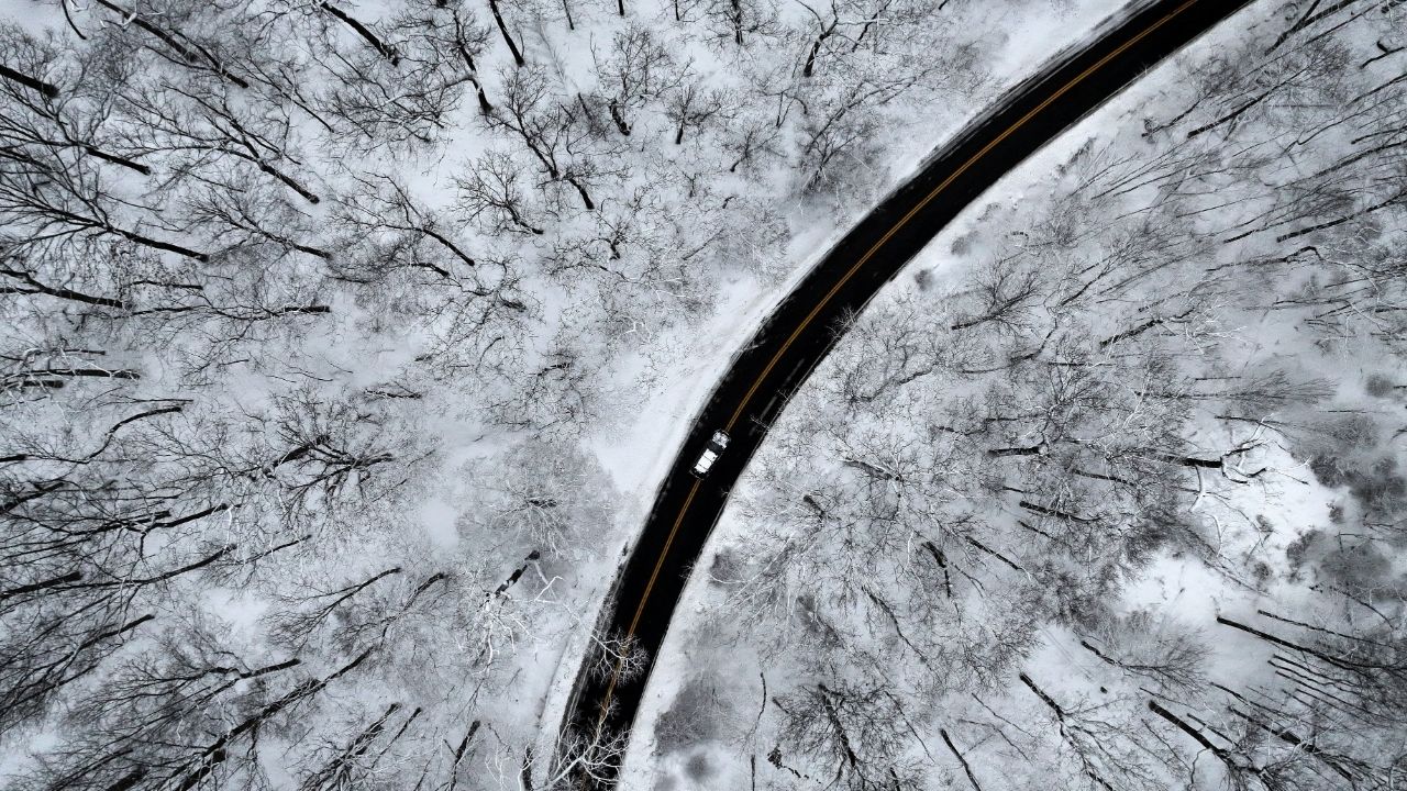 A drone view of a car driving through the snow covered woods of Blauvelt State Park in Orangetown, New York, U.S., December 27, 2025. (Reuters/Mike Segar)