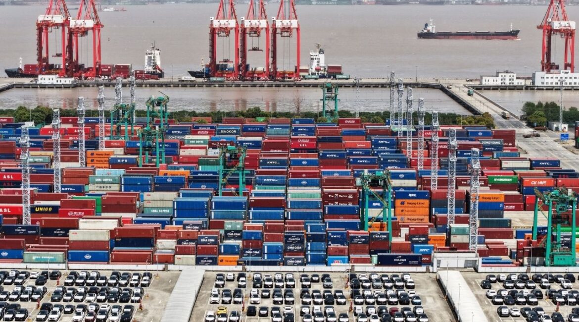 A drone view shows electric vehicles (EV) for export and containers sitting at a port in Shanghai, China April 13, 2025. China Daily via REUTERS