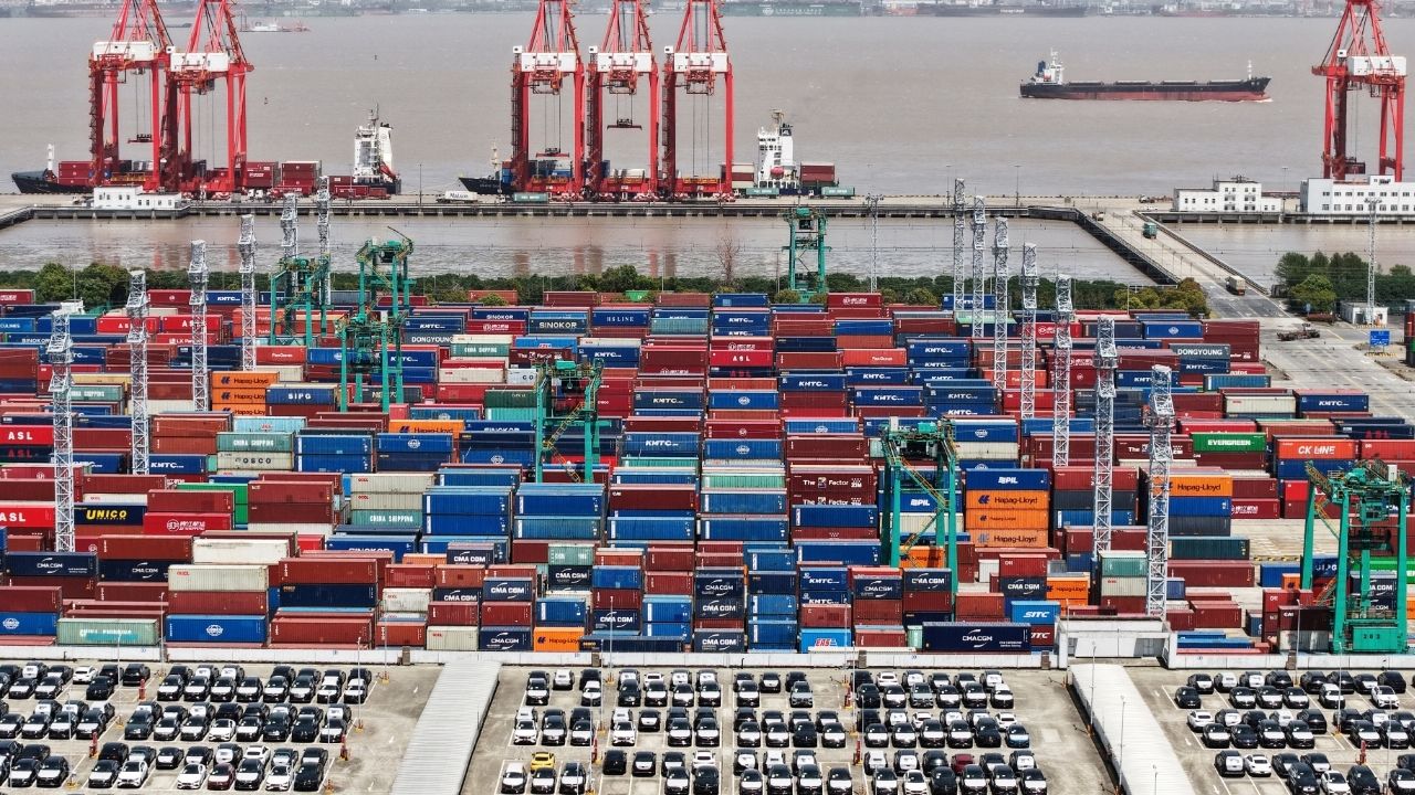 A drone view shows electric vehicles (EV) for export and containers sitting at a port in Shanghai, China April 13, 2025. China Daily via REUTERS