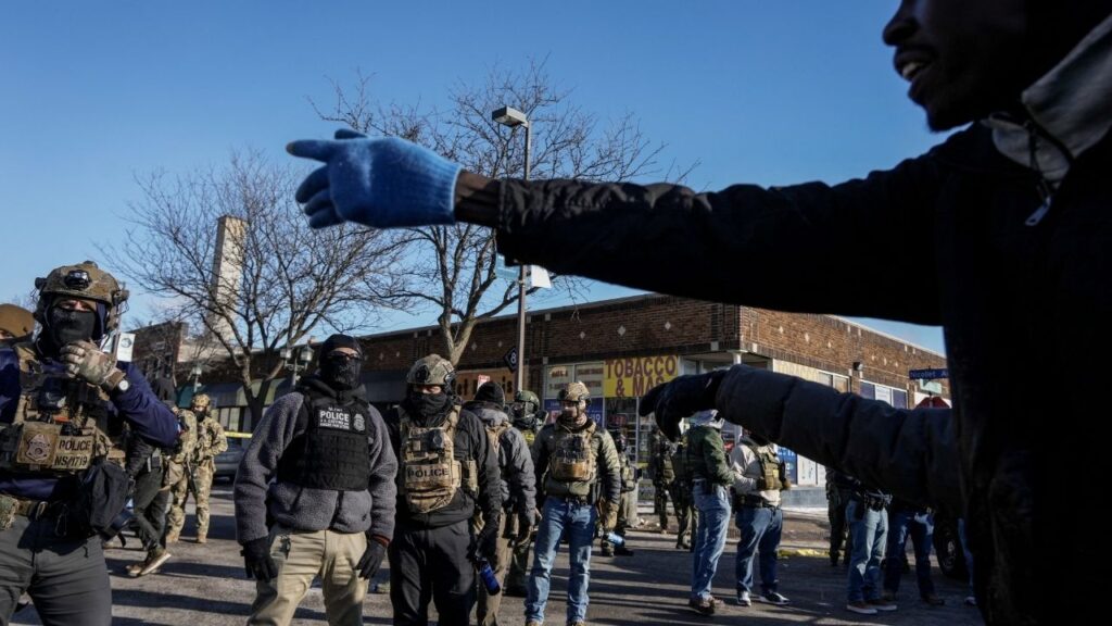 A man gestures next to federal agents at the scene of a shooting involving federal immigration agents in Minneapolis, Minnesota, U.S., January 24, 2026. (Reuters/Tim Evans)