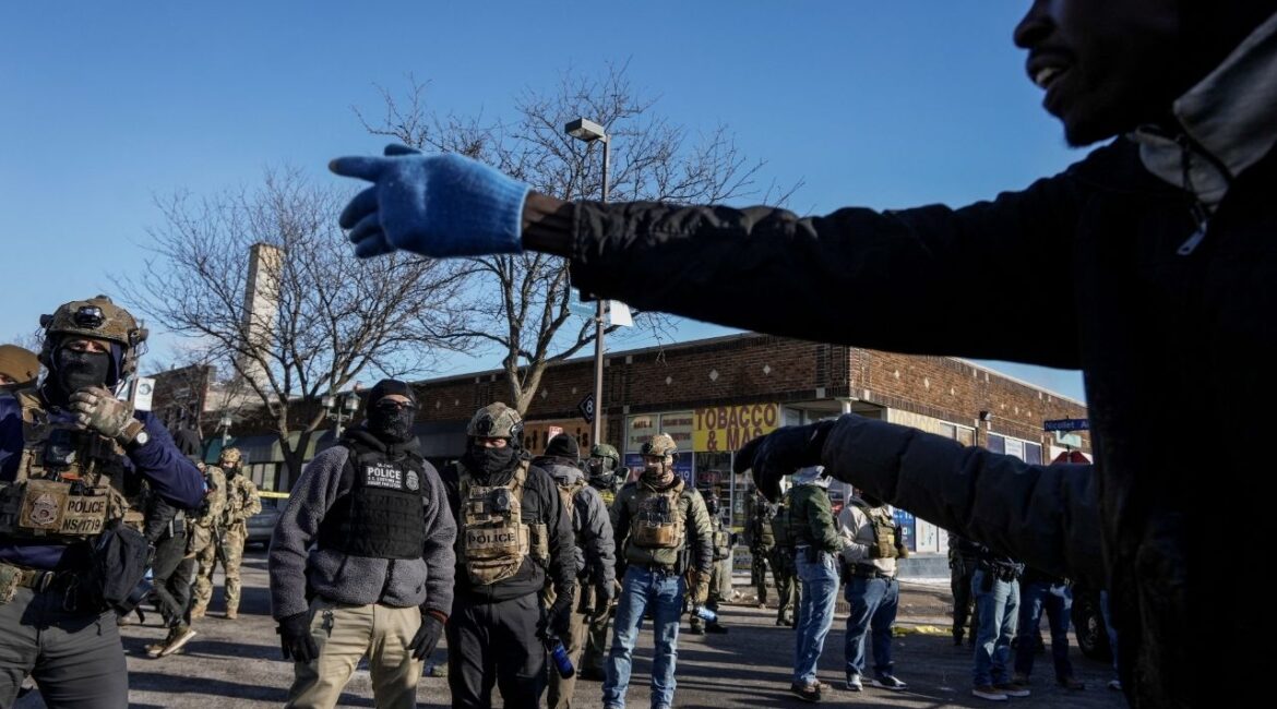 A man gestures next to federal agents at the scene of a shooting involving federal immigration agents in Minneapolis, Minnesota, U.S., January 24, 2026. (Reuters/Tim Evans)
