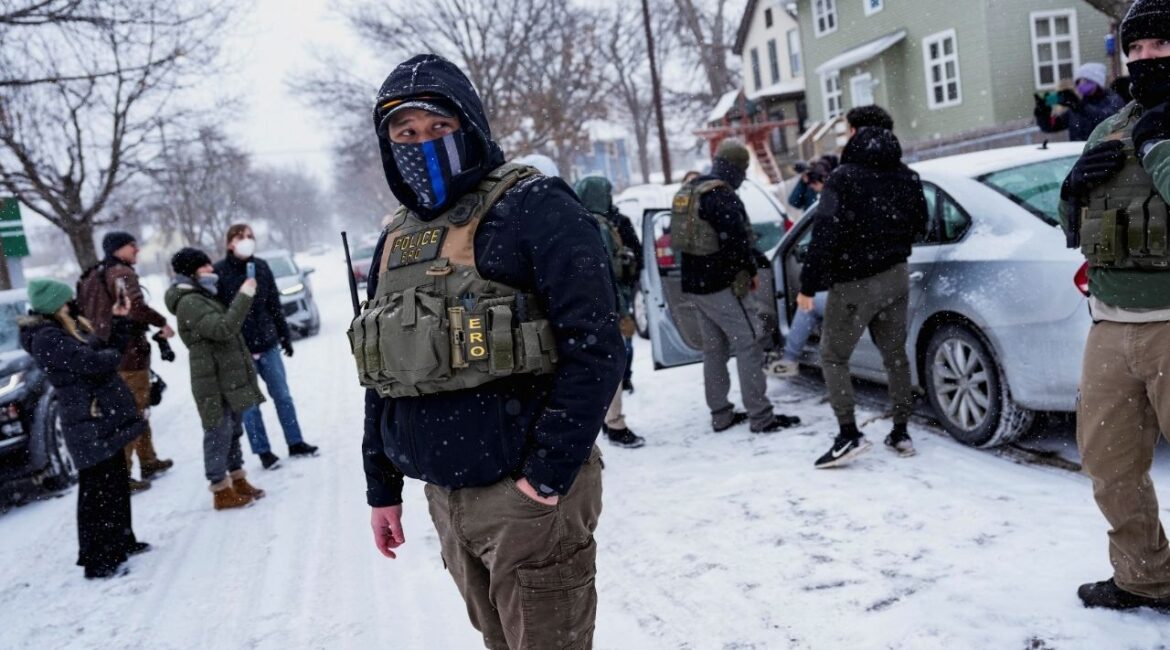 A member of the Enforcement and Removal Operations of ICE stands guard while a man is detained by Immigration and Customs Enforcement (ICE) agents during an immigration raid, days after an ICE agent fatally shot Renee Nicole Good, in Minneapolis, Minnesota, U.S., January 18, 2026. REUTERS/Leah Millis
