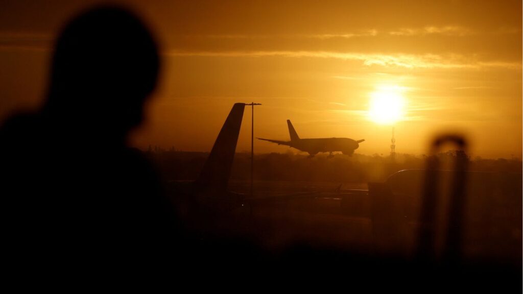 A passenger waits in departures as a British Airways plane lands at London Heathrow airport, London, Britain, November 15, 2025. (Reuters/Peter Cziborra/File Photo)