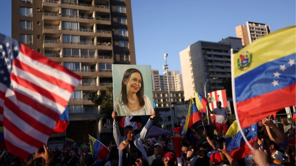 A person holds up an image depicting Venezuelan opposition leader Maria Corina Machado, as people celebrate after the U.S. struck Venezuela and captured its President Nicolas Maduro and his wife Cilia Flores, in Santiago, Chile January 3, 2026. (Reuters/Pablo Sanhueza)