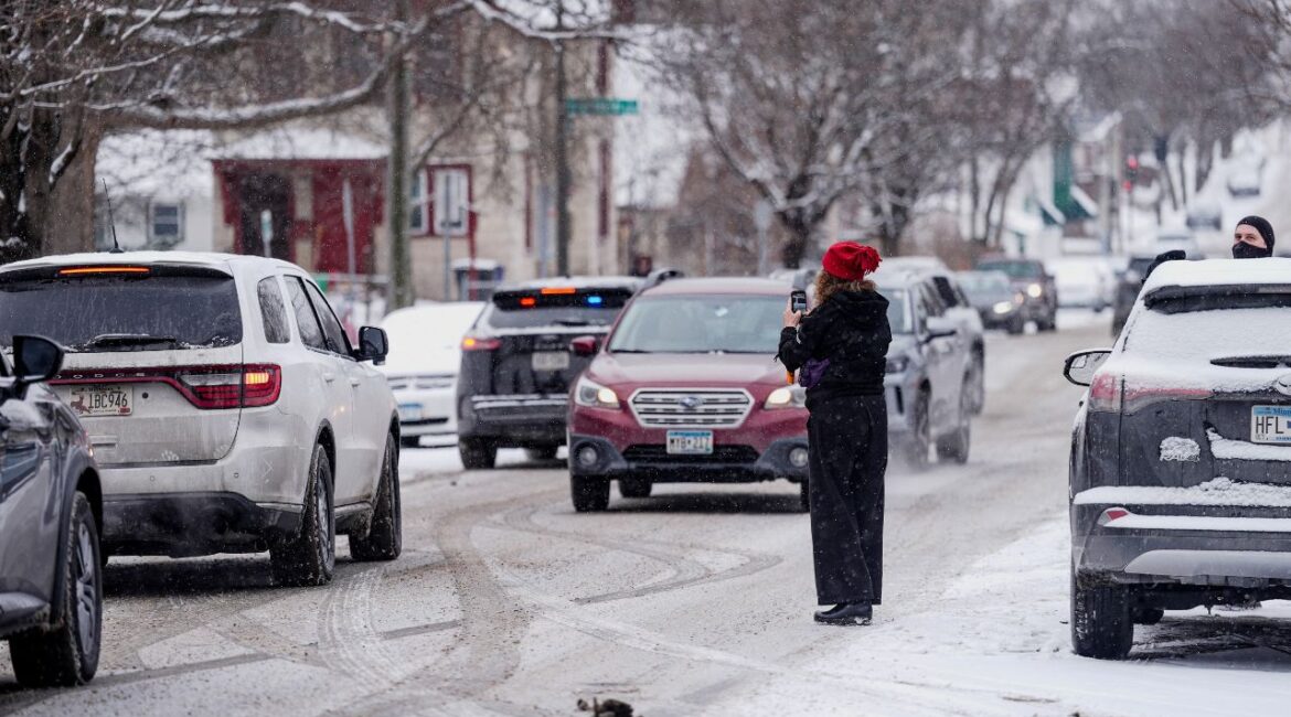 A person records with their phone while ICE agents and other law enforcement officers conduct an immigration raid at a home in St. Paul, Minnesota, U.S., days after an ICE agent fatally shot Renee Nicole Good, January 18, 2026. (Reuters/Leah Millis)