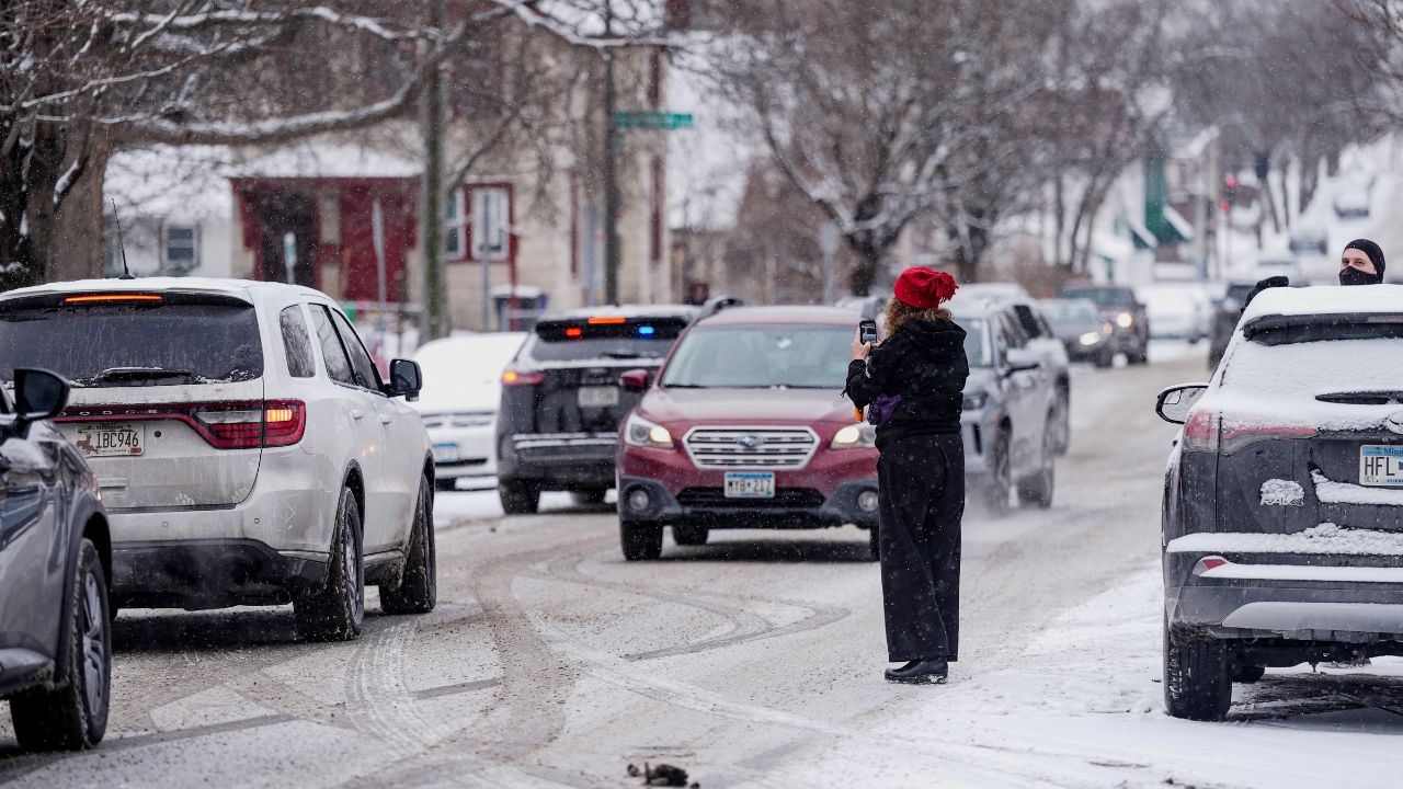 A person records with their phone while ICE agents and other law enforcement officers conduct an immigration raid at a home in St. Paul, Minnesota, U.S., days after an ICE agent fatally shot Renee Nicole Good, January 18, 2026. (Reuters/Leah Millis)