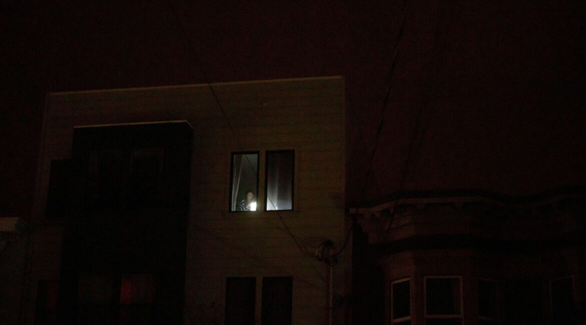 A person uses a flashlight inside an apartment during a blackout that affected about 130,000 residents, according to the Pacific Gas and Electric Company, in San Francisco, California, U.S., December 21, 2025. (Reuters/Carlos Barria)
