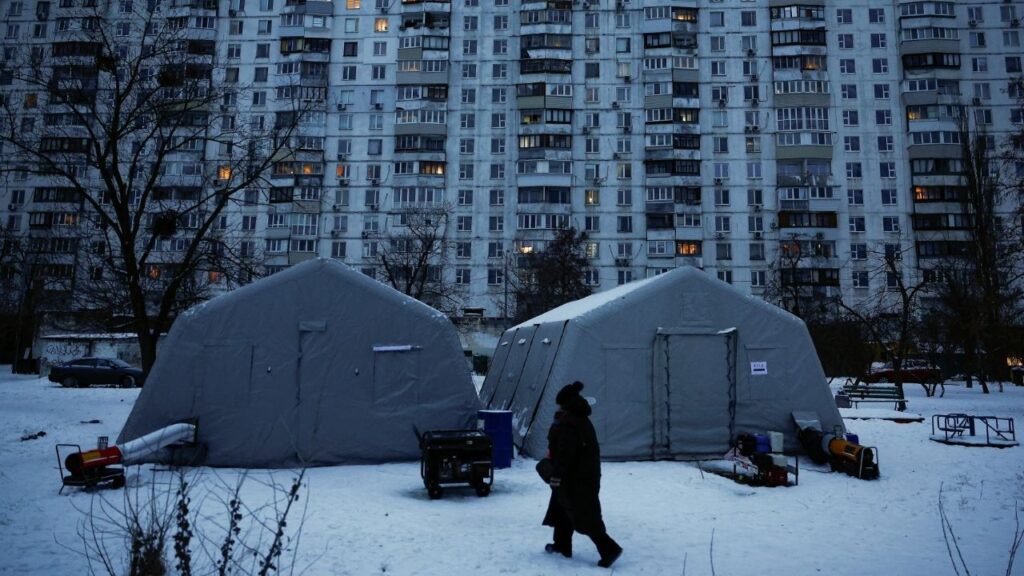 A person walks past a Point of Invincibility center, a government‑run shelter that provides basic services and heat during blackouts, set up next to an apartment building left without heating and facing long power cuts after critical civil infrastructure was hit by recent Russian missile and drone strikes, amid Russia’s attack on Ukraine, in Kyiv, Ukraine, January 23, 2026. (Reuters/Alina Smutko)