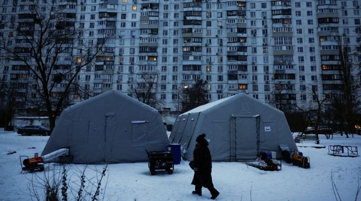 A person walks past a Point of Invincibility center, a government‑run shelter that provides basic services and heat during blackouts, set up next to an apartment building left without heating and facing long power cuts after critical civil infrastructure was hit by recent Russian missile and drone strikes, amid Russia’s attack on Ukraine, in Kyiv, Ukraine, January 23, 2026. (Reuters/Alina Smutko)