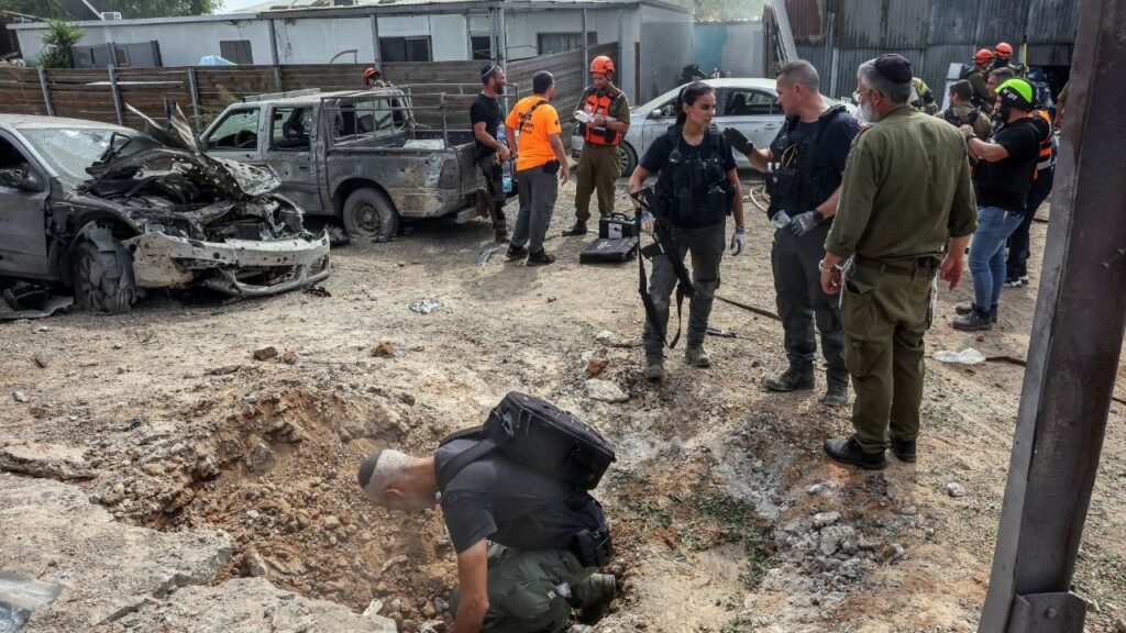 A security official investigates the crater formed when a projectile landed, after Hamas' armed wing said it attacked Tel Aviv with a missile salvo, amid the ongoing Israel-Hamas conflict, in Kfar Chabad, Israel, October 7, 2024. (Reuters File)
