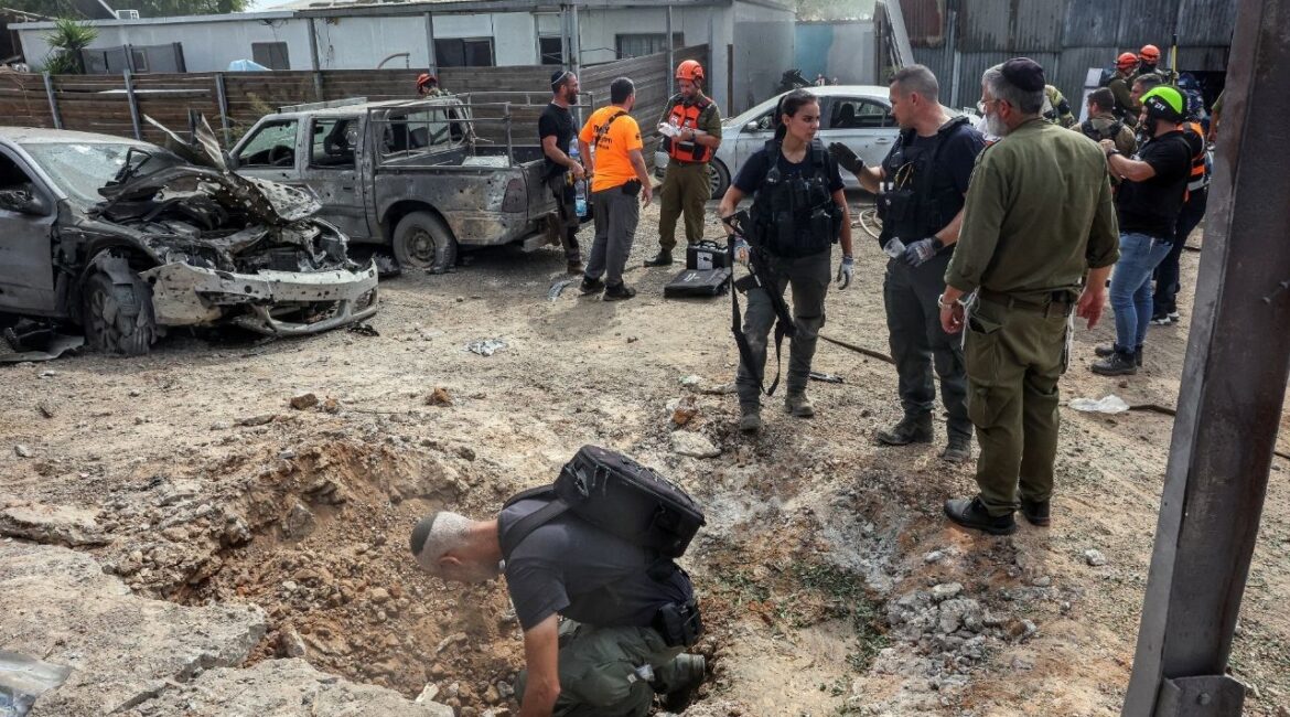 A security official investigates the crater formed when a projectile landed, after Hamas' armed wing said it attacked Tel Aviv with a missile salvo, amid the ongoing Israel-Hamas conflict, in Kfar Chabad, Israel, October 7, 2024. (Reuters File)