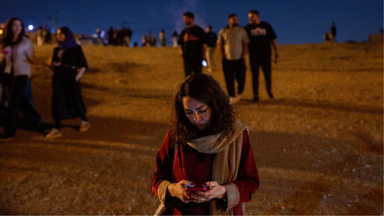 A woman checks her phone on a hill in Tehran, Iran on Oct. 2, 2025. Iran was plunged into a nationwide internet blackout on Thursday, Jan. 8, 2026, internet monitoring groups said, amid widespread protests over dire economic conditions and anger at the Islamic Republic. (Arash Khamooshi/The New York Times)