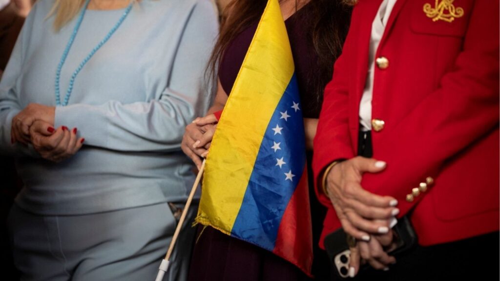 A woman holds a Venezuelan flag during a press conference on the U.S. strikes in Venezuela, in Doral, Miami-Dade County, Florida, U.S., January 5, 2026. (Reuters/Marco Bello)