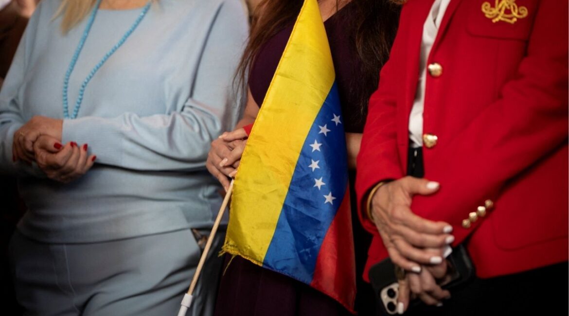 A woman holds a Venezuelan flag during a press conference on the U.S. strikes in Venezuela, in Doral, Miami-Dade County, Florida, U.S., January 5, 2026. (Reuters/Marco Bello)