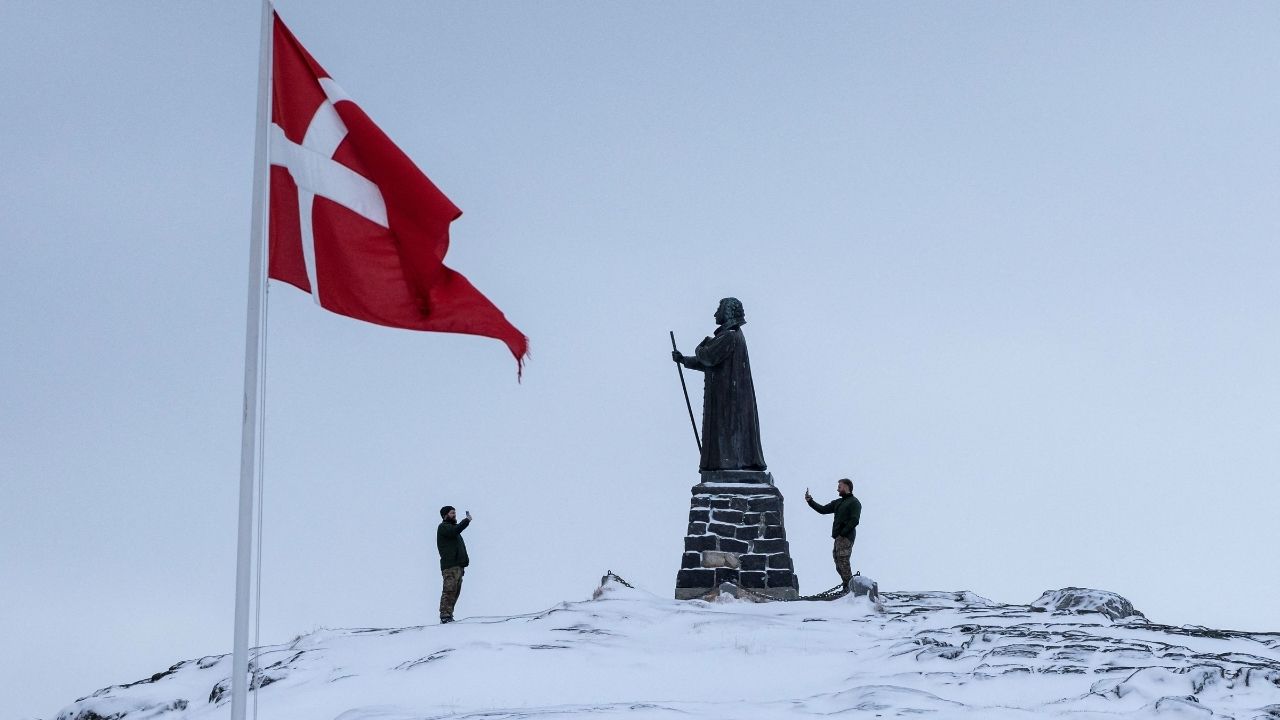 Danish soldiers take pictures next to the statue of Hans Egede, at Nuuk's old harbor, Greenland, January 18, 2026. (Reuters/Marko Djurica)