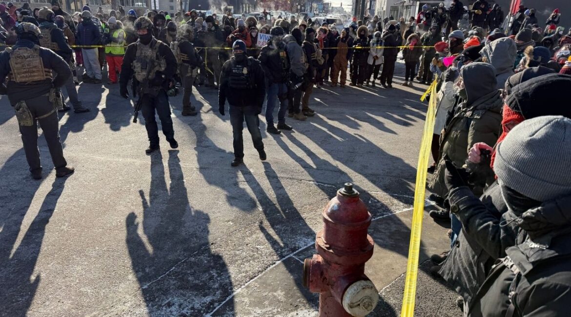 Demonstrators and civilians surround a perimeter held by federal agents near the intersection of 26th Street and Nicollet Avenue in Minneapolis, where federal law enforcement agents shot a person earlier on Saturday, Jan. 24, 2026. The scene was cordoned off with crime scene tape, as dozens of protesters, some wearing gas masks and goggles, blew whistles. ICE agents from Enforcement and Removal Operations were on site, as were several agents wearing U.S. Bureau of Prison Uniforms. (David Guttenfelder/The New York Times)