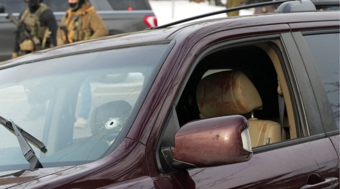 Federal agents gather near a vehicle with a bullet hole in the windshield after its driver was shot by a U.S. immigration agent, according to local and federal officials, in Minneapolis, Minnesota, January 7. (Reuters/Tim Evans)