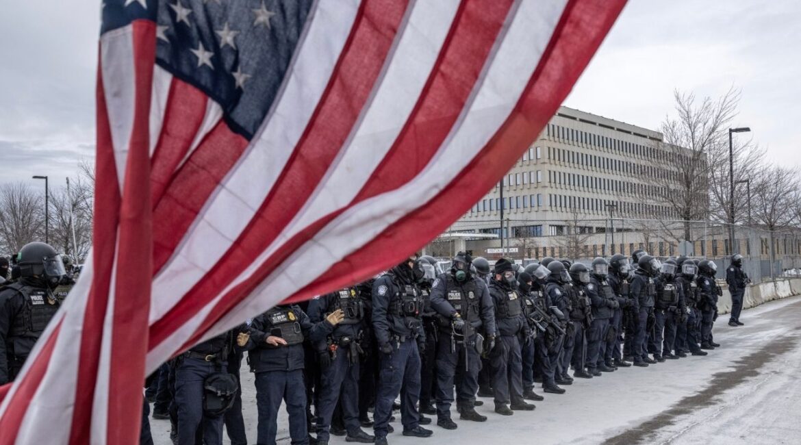Federal officers face off against protesters outside the Whipple Federal Building in Minneapolis on Thursday, Jan. 15, 2026. The Pentagon has ordered several hundred active-duty military police troops from Fort Bragg, N.C., to prepare for a possible deployment to Minnesota in the event that President Trump invokes the Insurrection Act, according to a senior U.S. official. (David Guttenfelder/The New York Times)