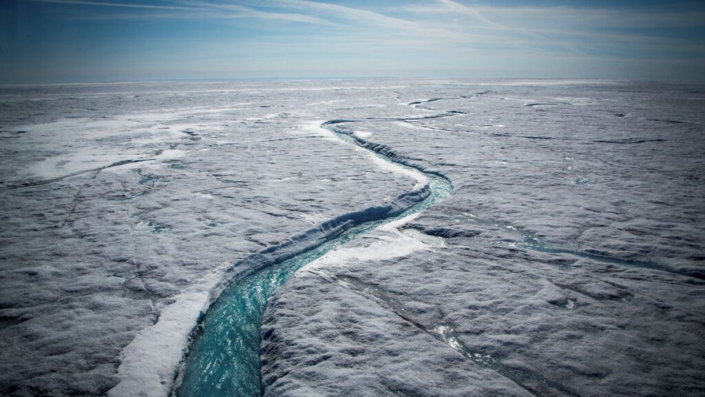 Image of glacial melt forming a river flowing atop the Greenland Ice Sheet