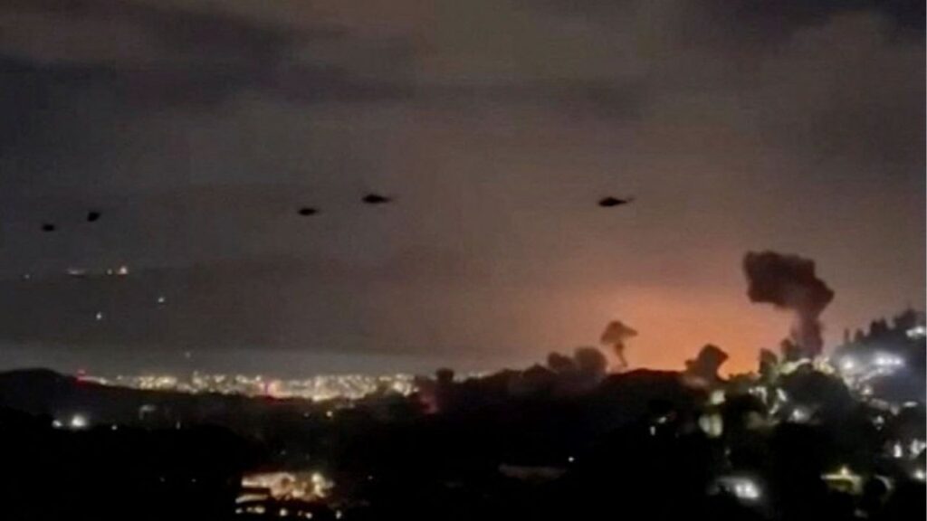 Helicopters fly past plumes of smoke rising from explosions, in Caracas, Venezuela, January 3, 2026 in this screen grab obtained from video obtained by Reuters. Video Obtained by Reuters/via REUTERS