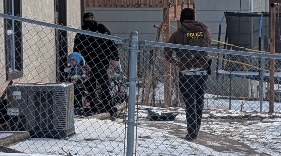 ICE agents stand next to a boy, who a witness identified as Liam Conejo Ramos, a five-year-old that school officials said was detained in Minneapolis, Minnesota, U.S., January 20, 2026. Rachel James/via REUTERS