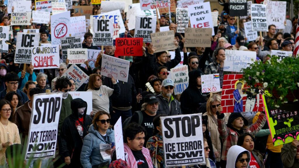 Image of protesters in San Antonio, Texas. Their signs say Stop ICE Terror Now