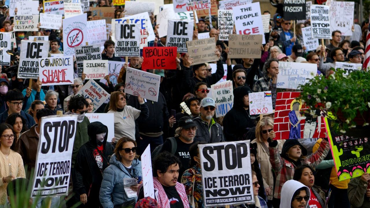 Image of protesters in San Antonio, Texas. Their signs say Stop ICE Terror Now