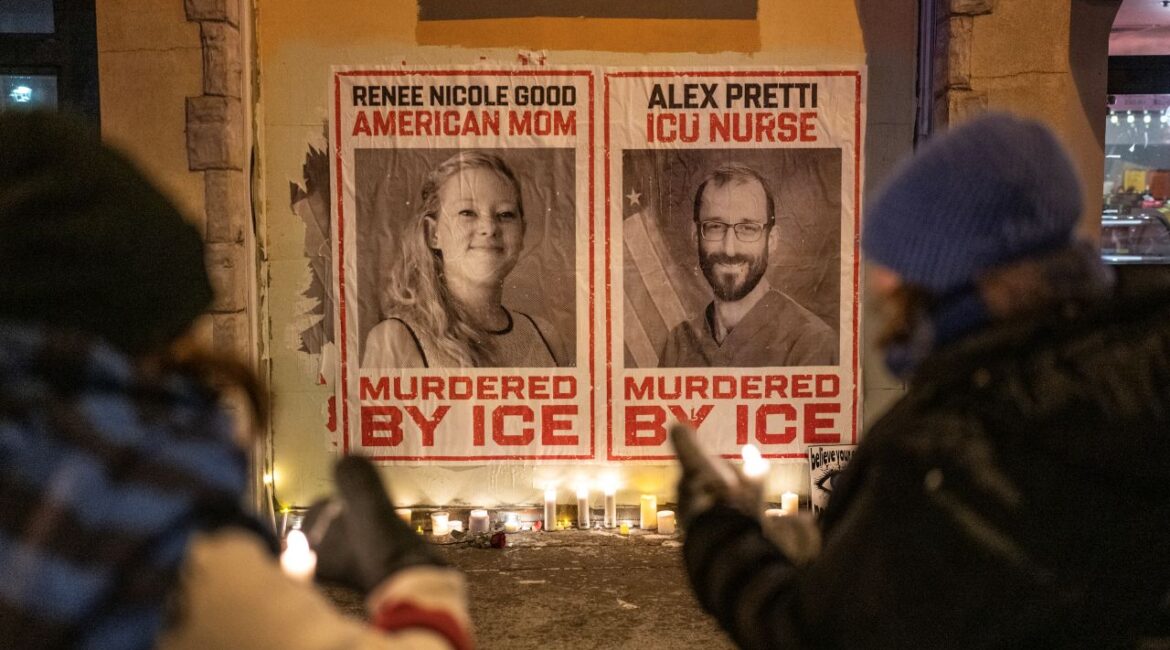 Image of mourners placing candles under posters of Renee Good and Alex Pretti on a cold night in Minneapolis.
