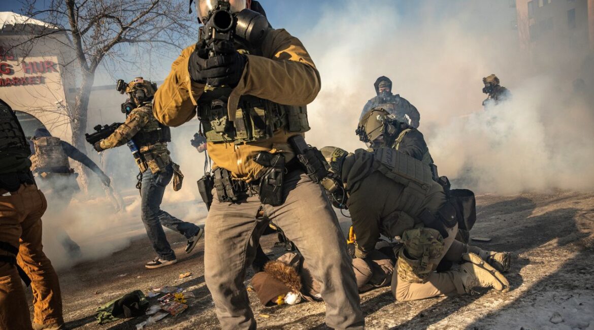 Image of masked federal agents pointing guns at protesters in Minneapolis