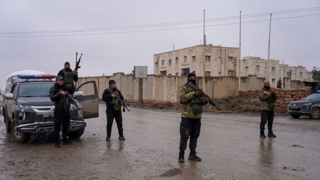 Members of the Syrian security forces stand guard outside al-Aqtan prison, where some Islamic State detainees are held, in Raqqa, Syria January 23, 2026. (Reuters/Karam al-Masri)