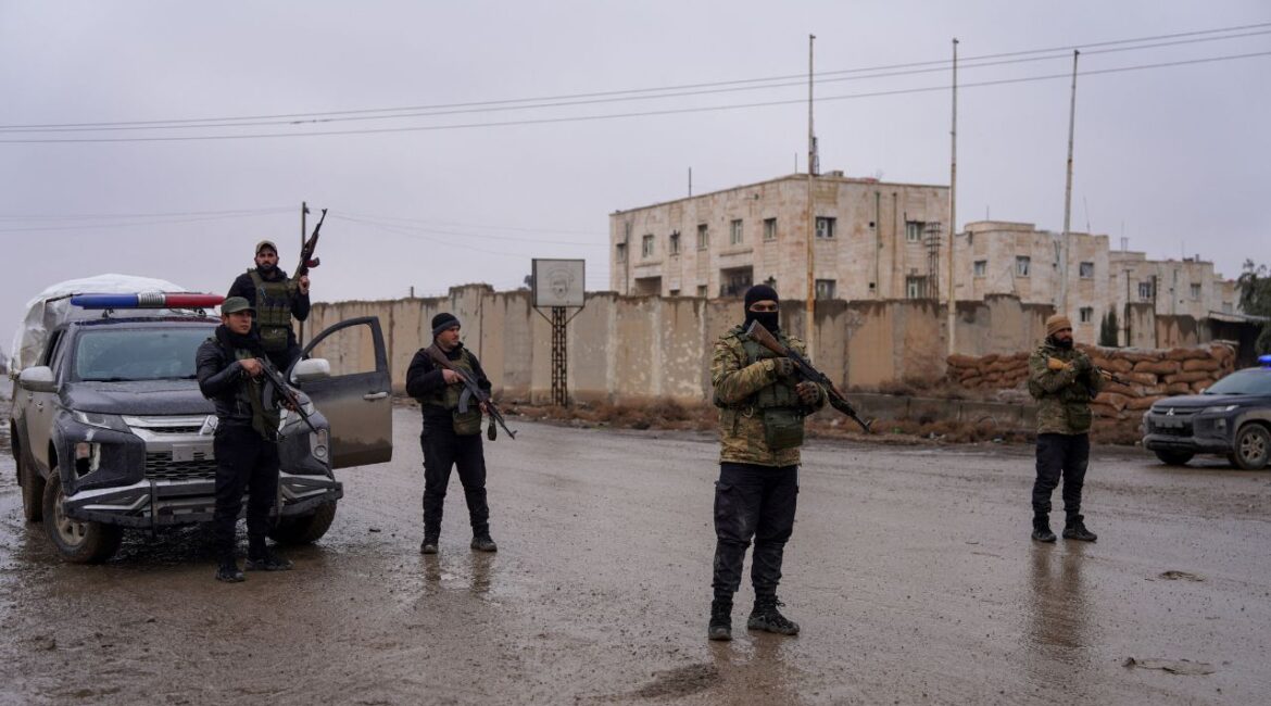 Members of the Syrian security forces stand guard outside al-Aqtan prison, where some Islamic State detainees are held, in Raqqa, Syria January 23, 2026. (Reuters/Karam al-Masri)