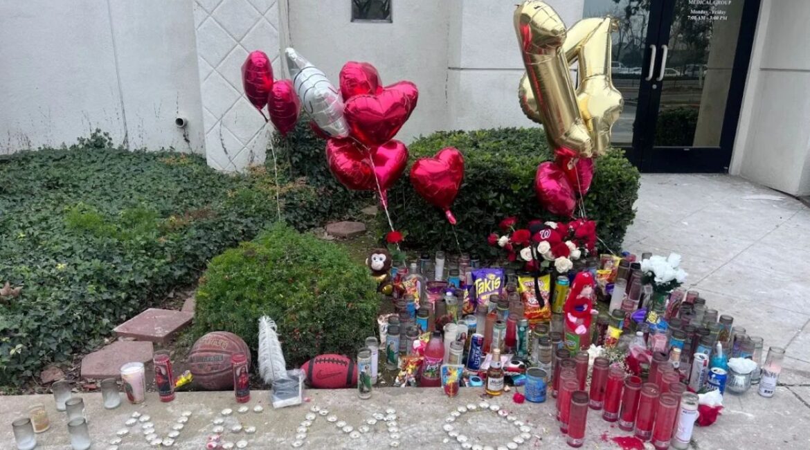 Image of a makeshift memorial with flowers, balloons, and chalk messages on a sidewalk