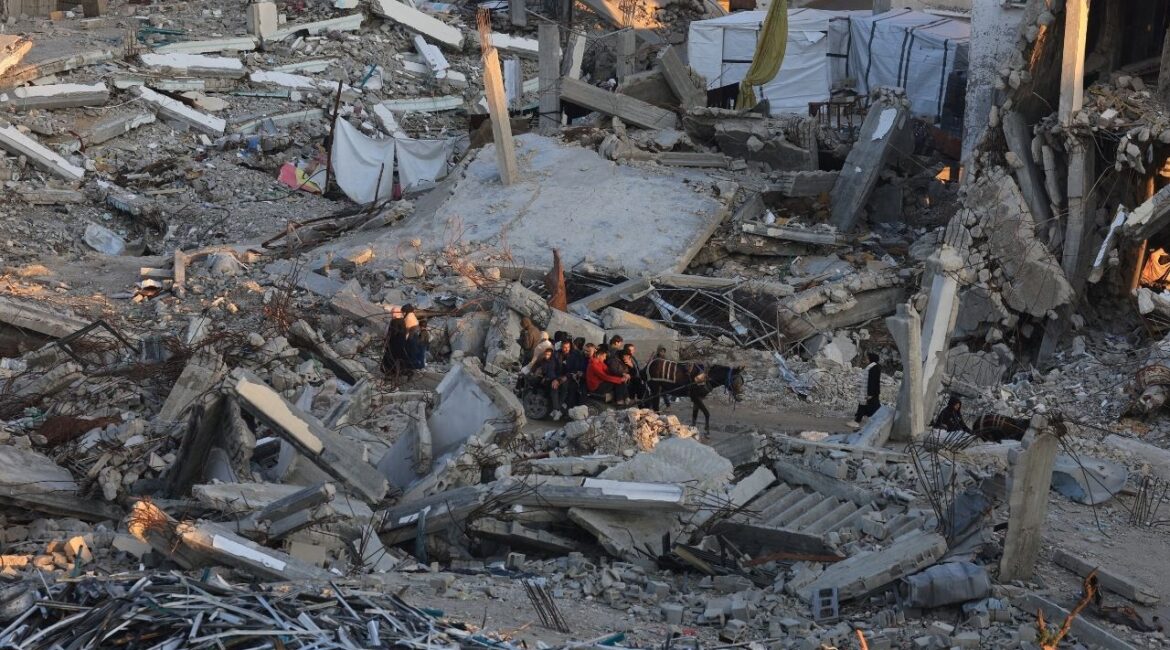 Palestinians move past the rubble of residential buildings destroyed during the war, in Gaza City, January 16, 2026. (Reuters/Dawoud Abu Alkas)